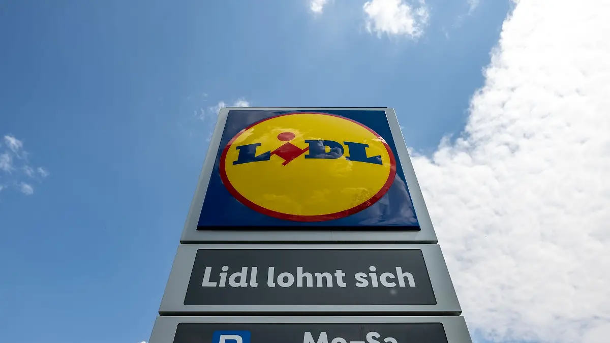 Eine Stele mit dem Logo des Discounters Lidl steht vor einer Filiale.