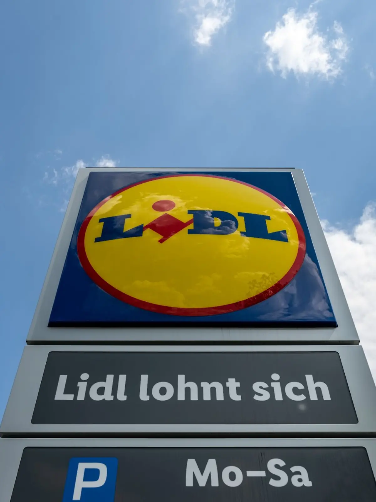 Eine Stele mit dem Logo des Discounters Lidl steht vor einer Filiale.