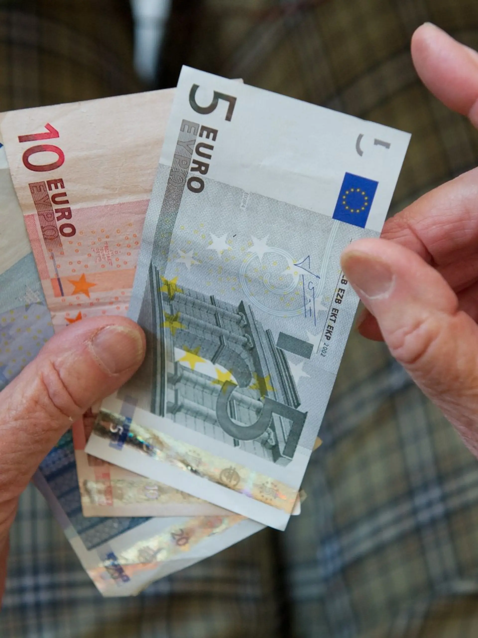 Eine ältere Frau zählt Geld.