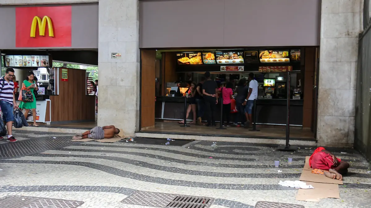 Social inequality has increased more and more in Rio de Janeiro, Brazil on December 24, 2016. On Christmas Eve, a group of homeless people slept in front of a McDonald's store while children played with what they had. People passed the place indifferently to the scene while they were shopping. (Photo by Luiz Souza/NurPhoto)