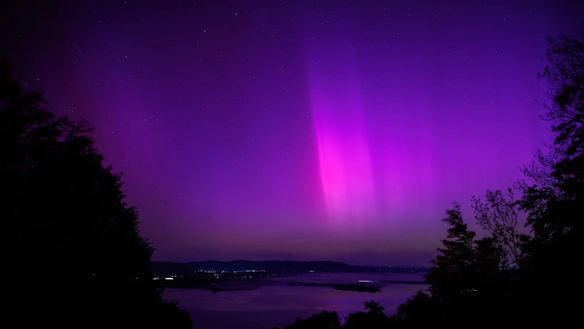 11.05.2024, Bayern, Kochel Am See: Polarlichter (Aurora borealis) leuchten am nächtlichen Himmel über dem Kochelsee. Foto: Matthias Balk/dpa +++ dpa-Bildfunk +++
