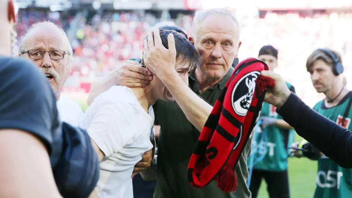 Christian Streich tröstet einen weinenden Fan