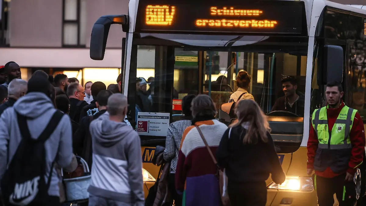 Reisende gehen vor dem Hauptbahnhof Duisburg zu den Ersatzbussen.