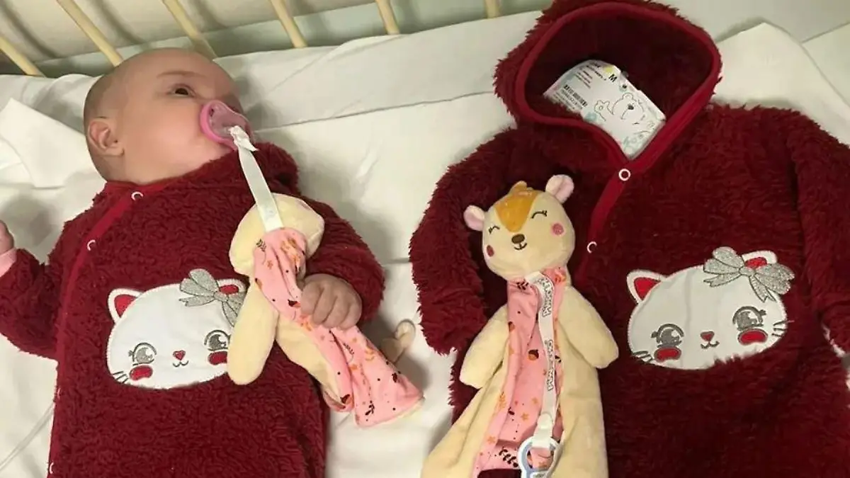 Die Zwillingsschwester der kleinen, verstorbenen Agnes liegt neben der leeren Babykleidung.