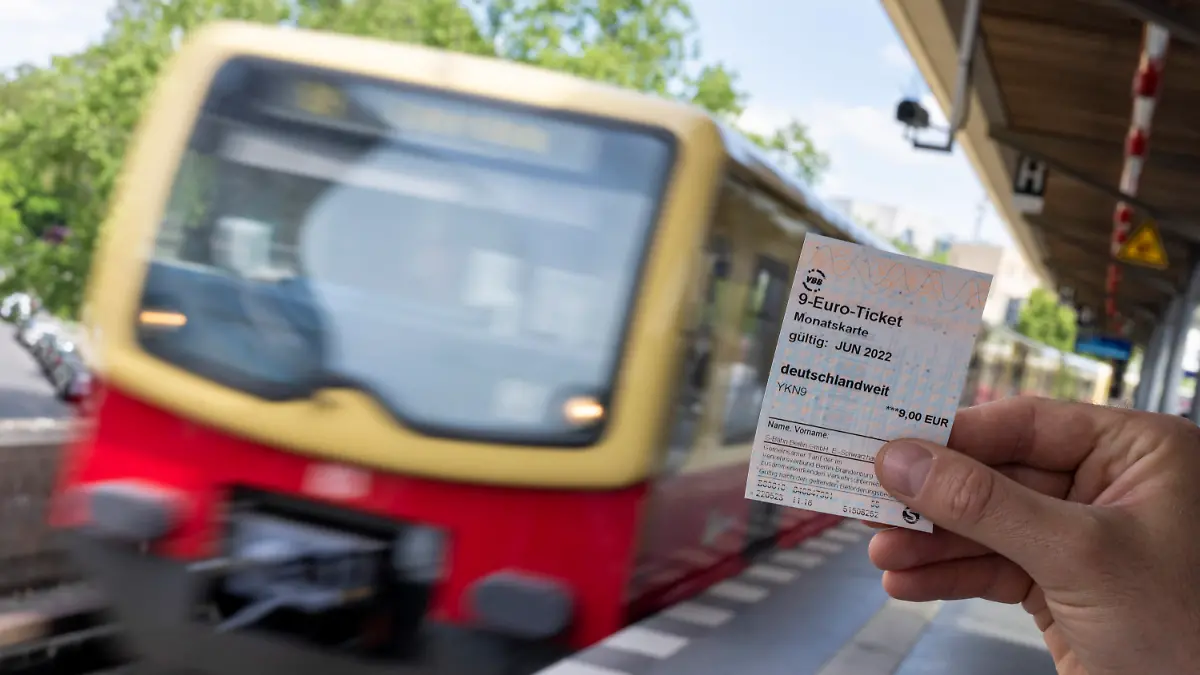 ILLUSTRATION - 23.05.2022, Berlin: Ein 9-Euro-Ticket ist vor dem Hintergrund einer einfahrenden S-Bahn zu sehen (gestelltes Foto). Die Deutsche Bahn und zahlreiche Verkehrsverbünde beginnen mit dem Verkauf des 9-Euro-Monatstickets. Mit dem Monatsticket können die Fahrgäste im Juni, Juli und August für jeweils 9 Euro bundesweit im öffentlichen Nah- und Regionalverkehr fahren. Foto: Monika Skolimowska/dpa +++ dpa-Bildfunk +++