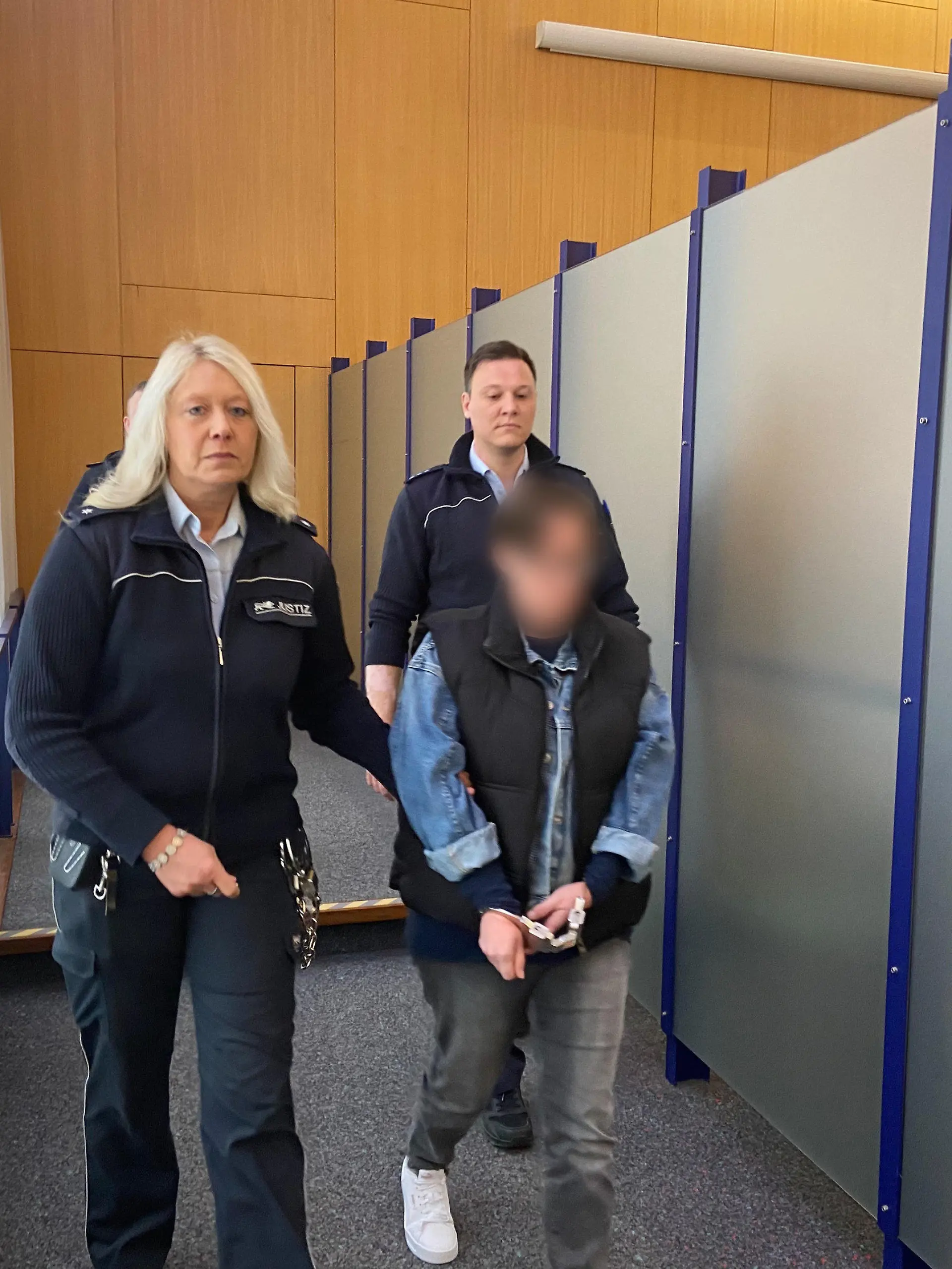 ARCHIV - 19.03.2024, Baden-Württemberg, Ulm: Die Angeklagte wird von Mitarbeitern der Justiz in den Gerichtssaal geführt. Weil sie ihr neugeborenes Baby in einem Glascontainer in Langenau (Alb-Donau-Kreis) ausgesetzt haben soll, muss sich eine 38 Jahre alte Frau von diesem Dienstag an (8.30 Uhr) vor dem Landgericht Ulm verantworten. Die Staatsanwaltschaft wirft ihr versuchten Totschlag in Tateinheit mit Aussetzung vor. Das Kind blieb unverletzt. Ein Passant hatte das Baby nachts in dem Glascontainer entdeckt und die Rettungskräfte alarmiert. (zu dpa: «Baby in Glascontainer ausgesetzt - Urteil erwartet») Foto: Tatjana Bojic/dpa +++ dpa-Bildfunk +++
