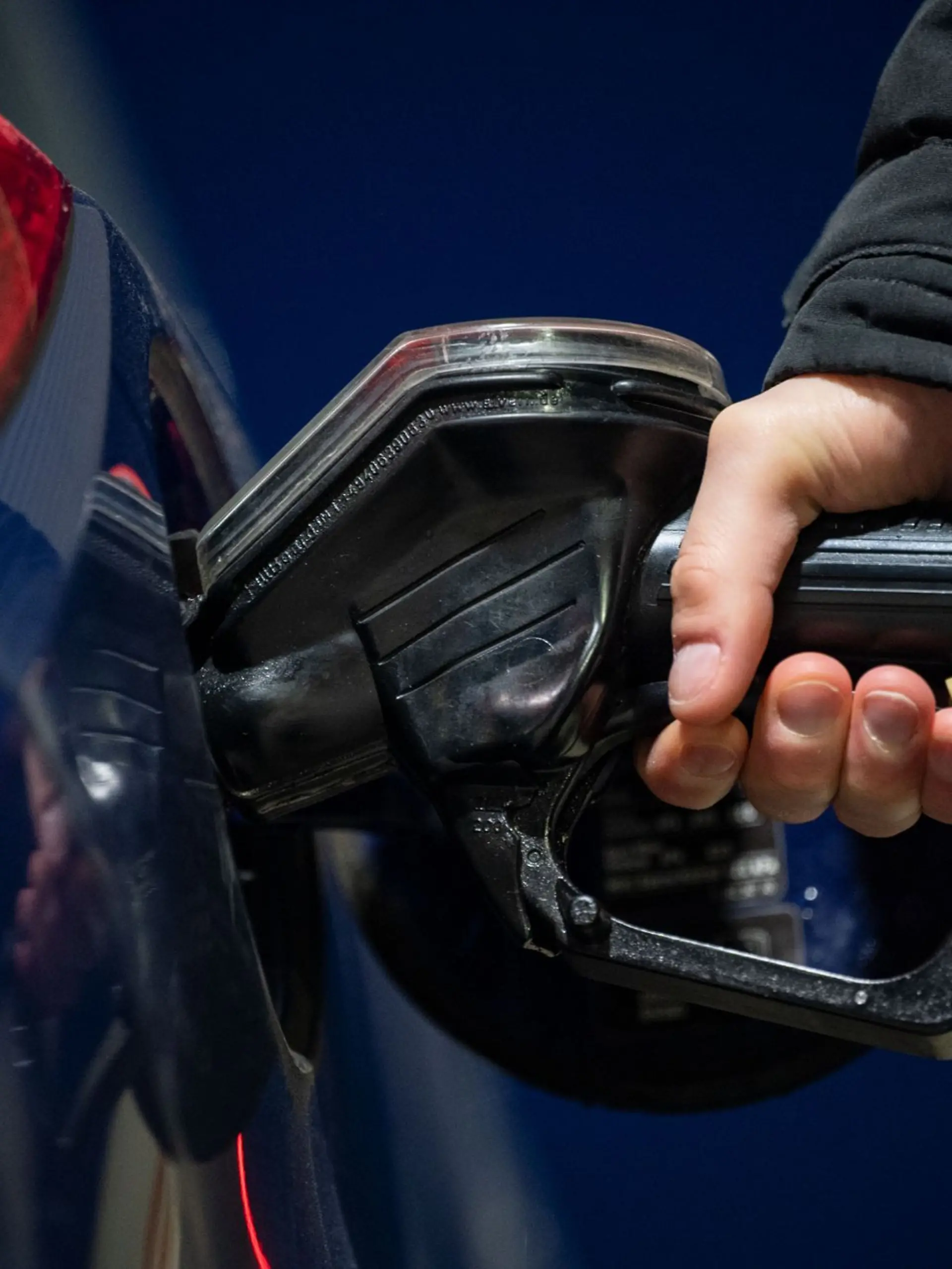 Ein Mann tankt seinen Wagen an einer Tankstelle.