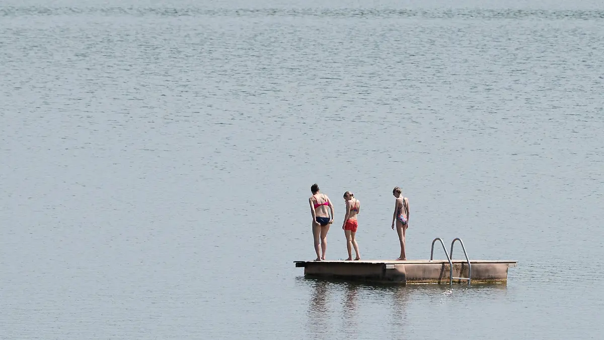 Badegäste stehen im Badesee Birkwitz auf einer Badeinsel.