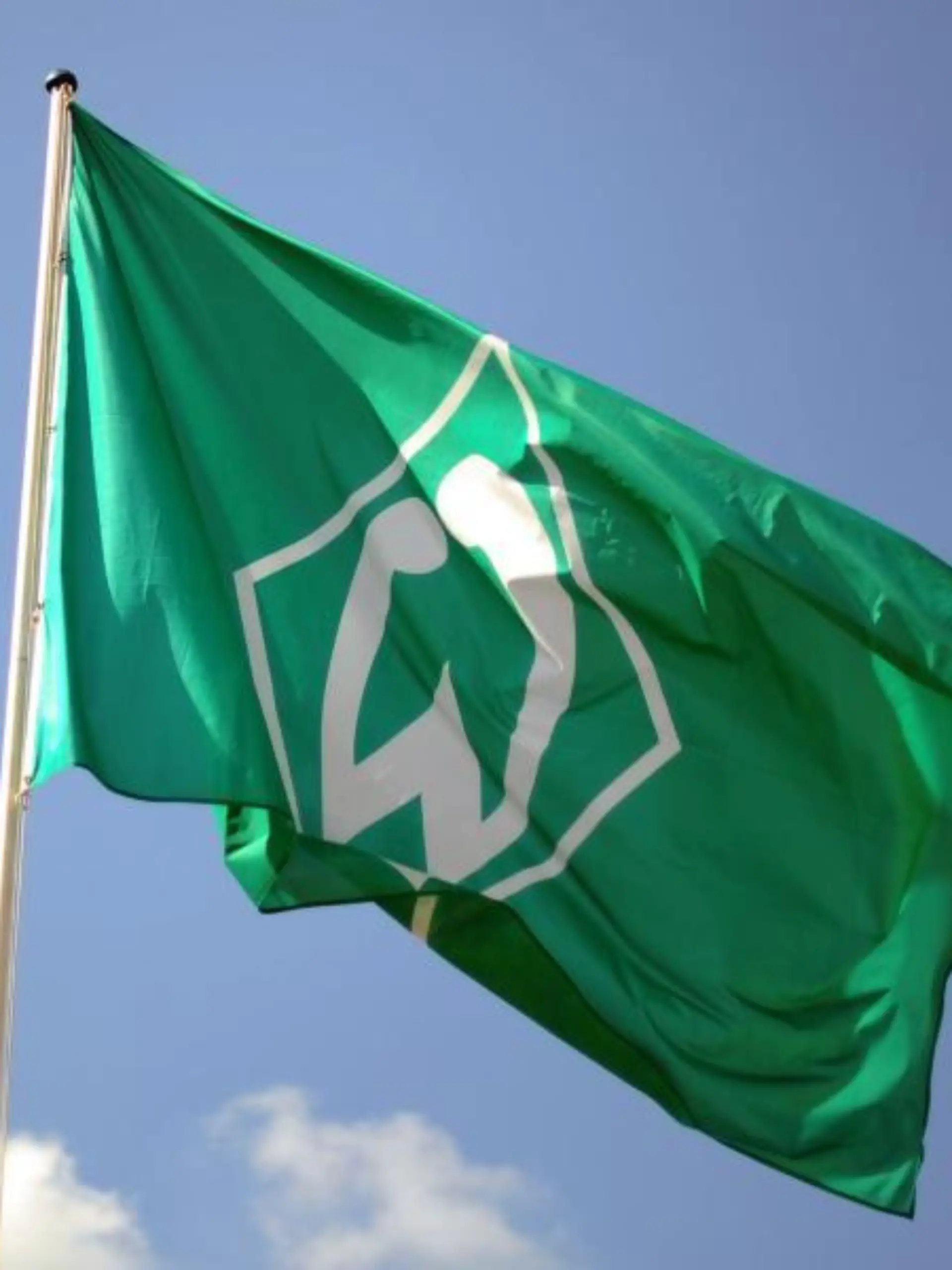 Eine Fahne mit dem Logo vom SV Werder Bremen weht im Wind