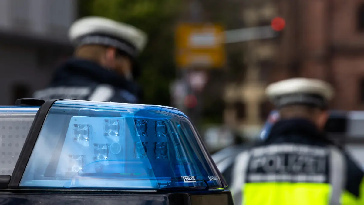 ARCHIV - 05.05.2021, Baden-Württemberg, Freiburg: Zwei Polizeibeamte stehen zwischen zwei Einsatzfahrzeugen der Polizei. (zu dpa: «13-jähriger Verdächtiger: Stadt stand vor Tat im Kontakt mit Familie») Foto: Philipp von Ditfurth/dpa +++ dpa-Bildfunk +++