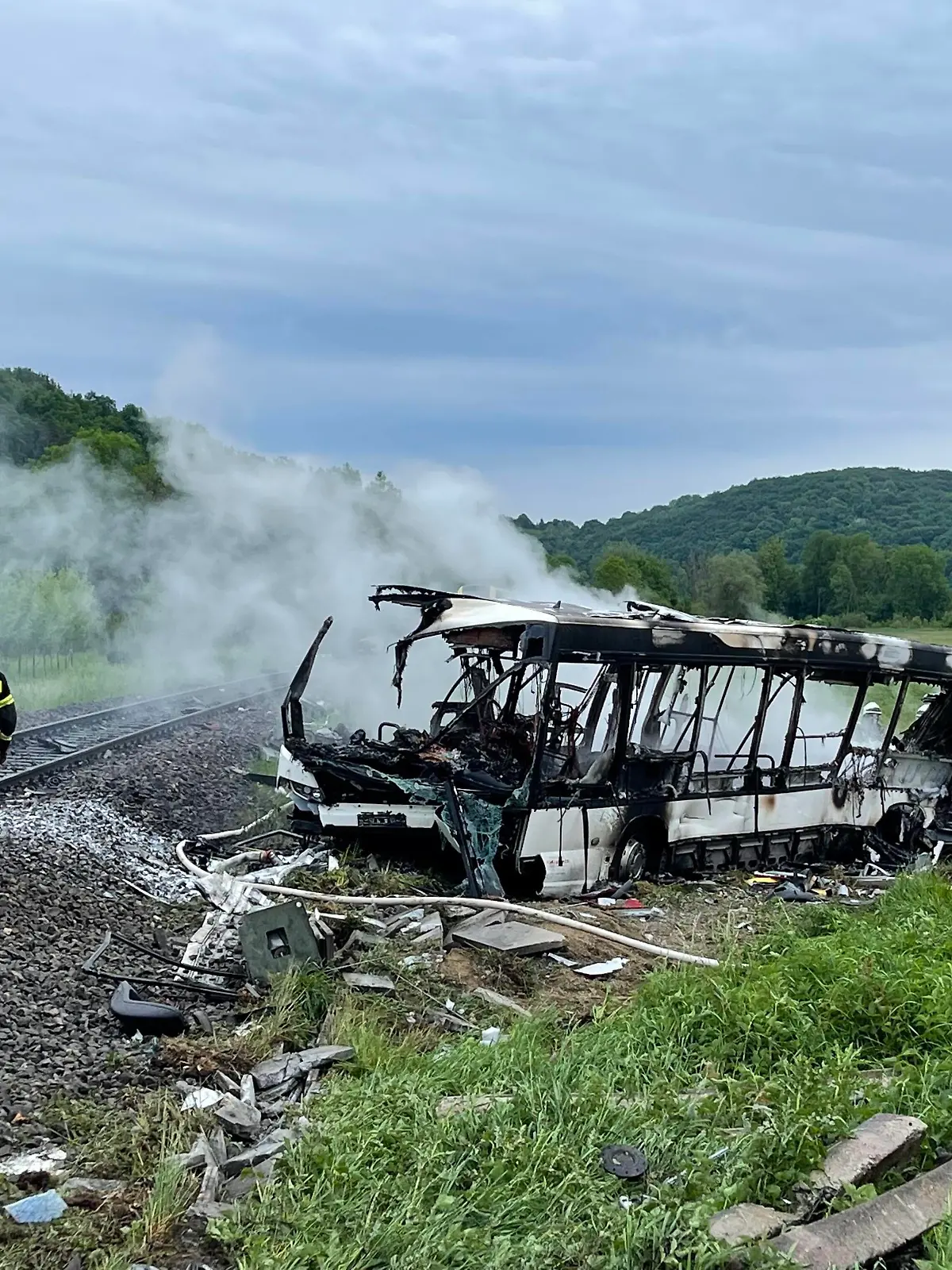  Regionalbahn und Bus am Bahnübergang, 24.05.2022, Baden-Württemberg, Blaustein: Feuerwehrmänner löschen einen Brand in einem Bus, der in der Nähe von Ulm mit einem Zug kollidierte. Am Morgen hatte sich bei Arnegg ein schweres Zugunglück ereignet. Blaustein Baden-Württemberg Deutschland Blaustein *** Regional train and bus at level crossing, 24 05 2022, Baden Württemberg, Blaustein firefighters extinguish a fire in a bus that collided with a train near Ulm In the morning, a serious train accident had occurred near Arnegg Blaustein Baden Württemberg Germany Blaustein Copyright: x xonw-imagesx/xDennisxStraubx