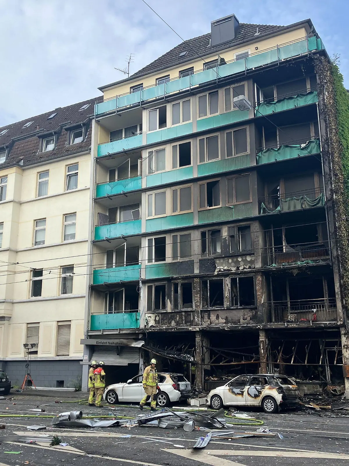 dpatopbilder - 16.05.2024, Nordrhein-Westfalen, Düsseldorf: Trümmer liegen auf einer Straße in Düsseldorf vor einem haus, in dem ein Brand wütete. Bei dem Brand in Düsseldorf sind mehrere Menschen ums Leben gekommen und weitere verletzt worden. Wie die Feuerwehr mitteilte, war in der Nacht zum Donnerstag aus bislang ungeklärter Ursache ein in einem Wohnhaus integrierter Kiosk in Brand geraten. Foto: Jana Glose/dpa +++ dpa-Bildfunk +++