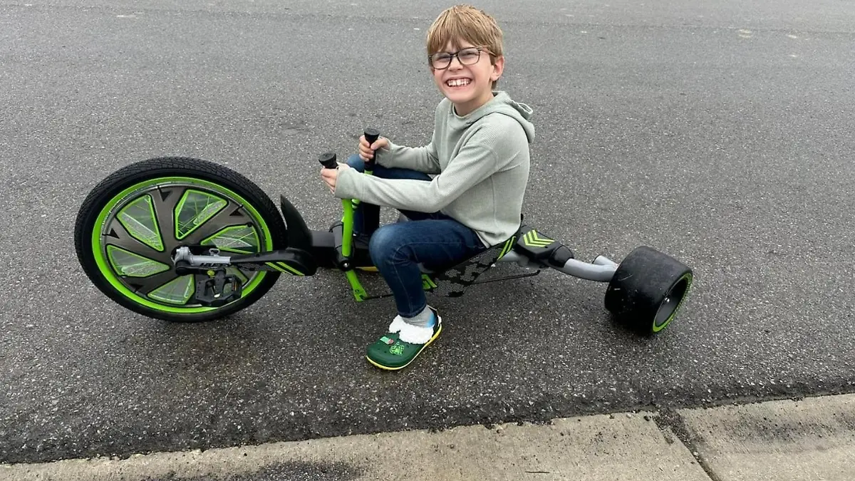 Ein kleiner Junge auf einem Dreirad.