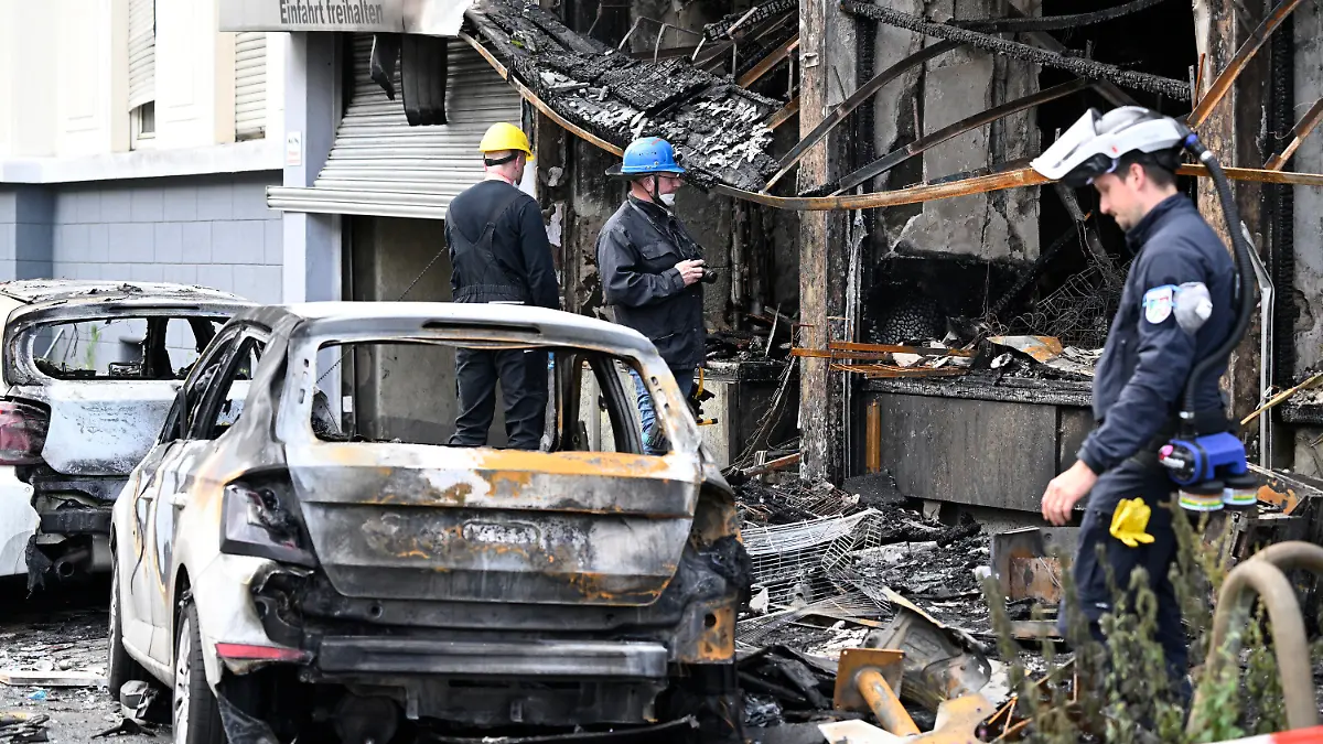 16.05.2024, Nordrhein-Westfalen, Düsseldorf: Mitarbeiter der Kriminaltechnischen Untersuchung (KTU) besichtigen ein Wohnhaus, in dem ein Brand wütete. Bei dem Brand in Düsseldorf sind mehrere Menschen ums Leben gekommen und weitere verletzt worden. Wie die Feuerwehr mitteilte, war in der Nacht zum Donnerstag aus bislang ungeklärter Ursache ein in einem Wohnhaus integrierter Kiosk in Brand geraten. Foto: Roberto Pfeil/dpa +++ dpa-Bildfunk +++
