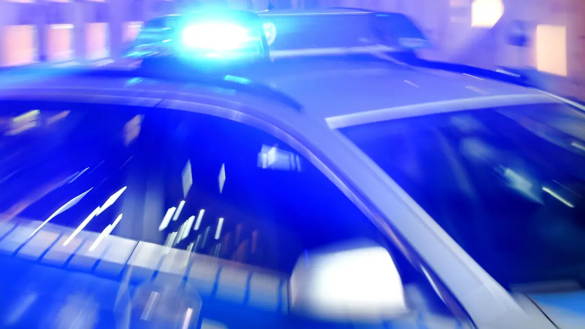 ARCHIV - 06.08.2015, Schleswig-Holstein, Flensburg: ILLUSTRATION - Ein Streifenwagen der Polizei steht mit eingeschaltetem Blaulicht auf der Straße. Die Polizei hat einen Mann festgenommen, der mehrere Tankstellen überfallen haben soll. (zu dpa: «Mehrere Tankstellen überfallen: Polizei nimmt 19-Jährigen fest») Foto: Carsten Rehder/dpa +++ dpa-Bildfunk +++