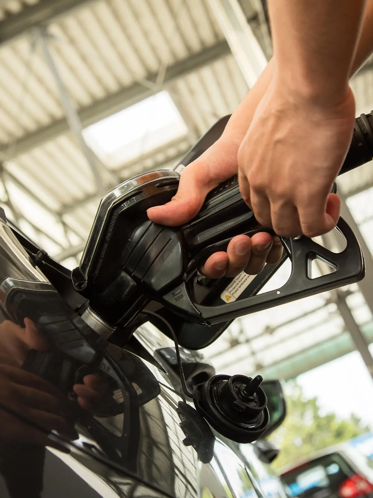 ILLUSTRATION - Ein Mann betankt am 08.07.2021 in Hamburg sein Auto (gestellte Szene). Foto: Christin Klose || Modellfreigabe vorhanden