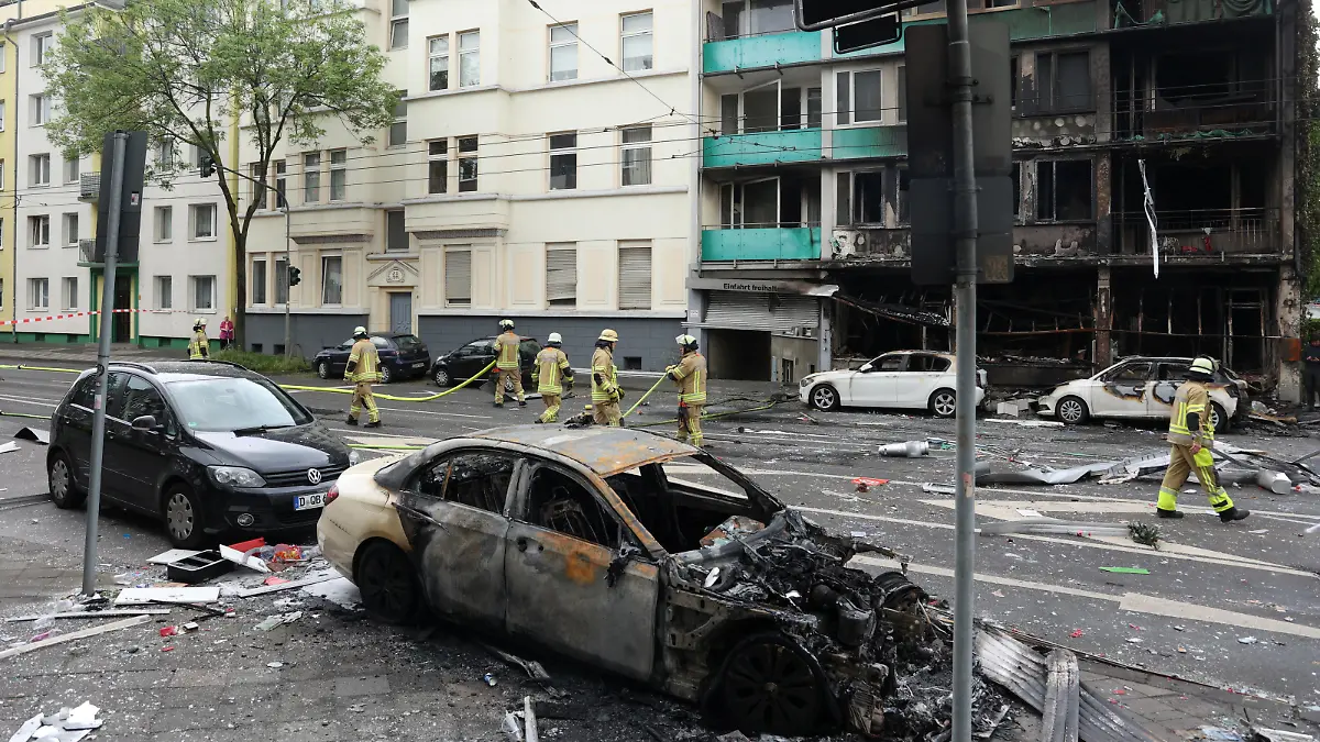 A damaged car stands opposite a destroyed building after an overnight explosion inside a kiosk killed three people and injured sixteen others in the western German city of Duesseldorf, Germany, May 16, 2024. REUTERS/Thilo Schmuelgen