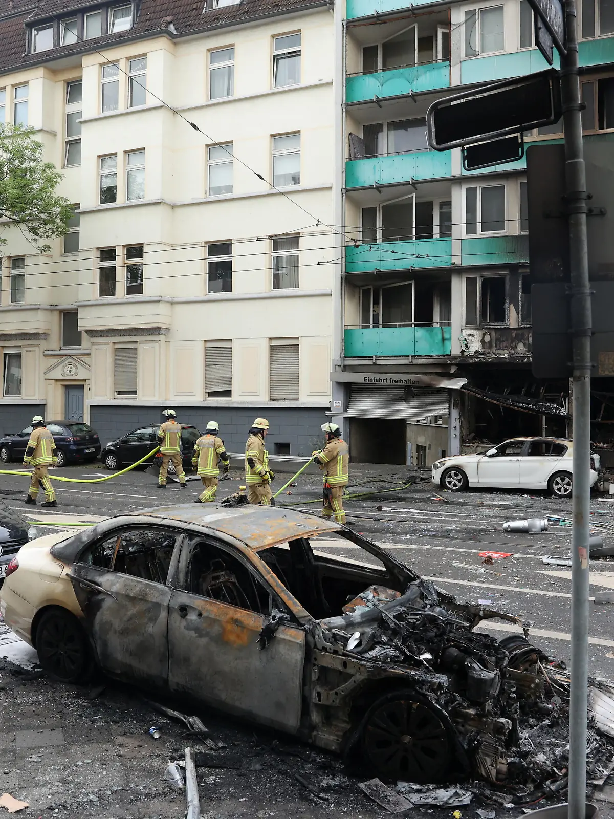A damaged car stands opposite a destroyed building after an overnight explosion inside a kiosk killed three people and injured sixteen others in the western German city of Duesseldorf, Germany, May 16, 2024.    REUTERS/Thilo Schmuelgen