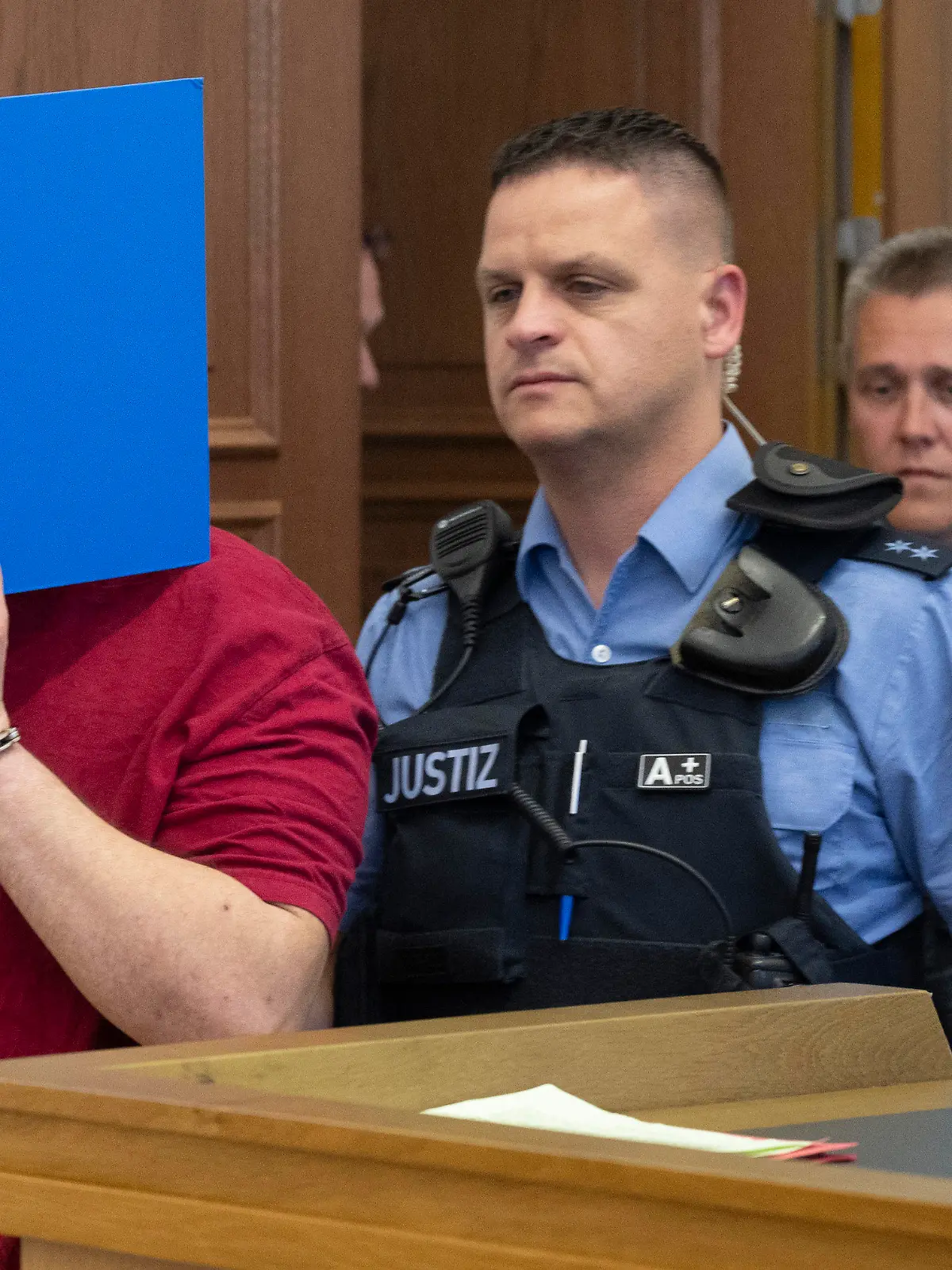 13.06.2023, Hessen, Gießen: Der Angeklagte (l) wird von Justizwachtmeistern in den Verhandlungssaal geführt. Die Staatsanwaltschaft wirft dem zum Tatzeitpunkt 30-Jährigen vor, die 14 Jahre alte Schülerin Ayleen aus dem südbadischen Gottenheim in Baden-Württemberg im Juli 2022 umgebracht zu haben. Die Ermittler gehen davon aus, dass die Tat sexuell motiviert war. Foto: Boris Roessler/dpa +++ dpa-Bildfunk +++