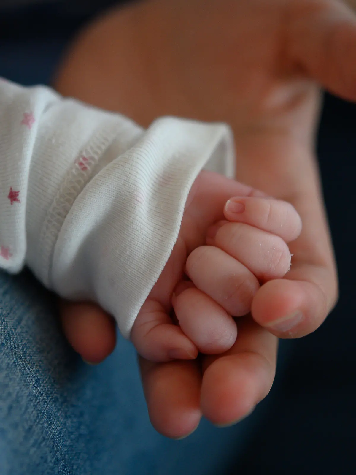ARCHIV - 02.02.2020, Baden-Württemberg, Stuttgart: Die Hand eines zwei Wochen altes Neugeborenen liegt in der Hand seiner Mutter. In Polen hat eine 13-jährige Schülerin auf einer Klassenfahrt ein Baby zur Welt gebracht. (zu dpa: «Polen: 13-Jährige bringt auf Klassenfahrt Kind zur Welt») Foto: Sebastian Gollnow/dpa +++ dpa-Bildfunk +++