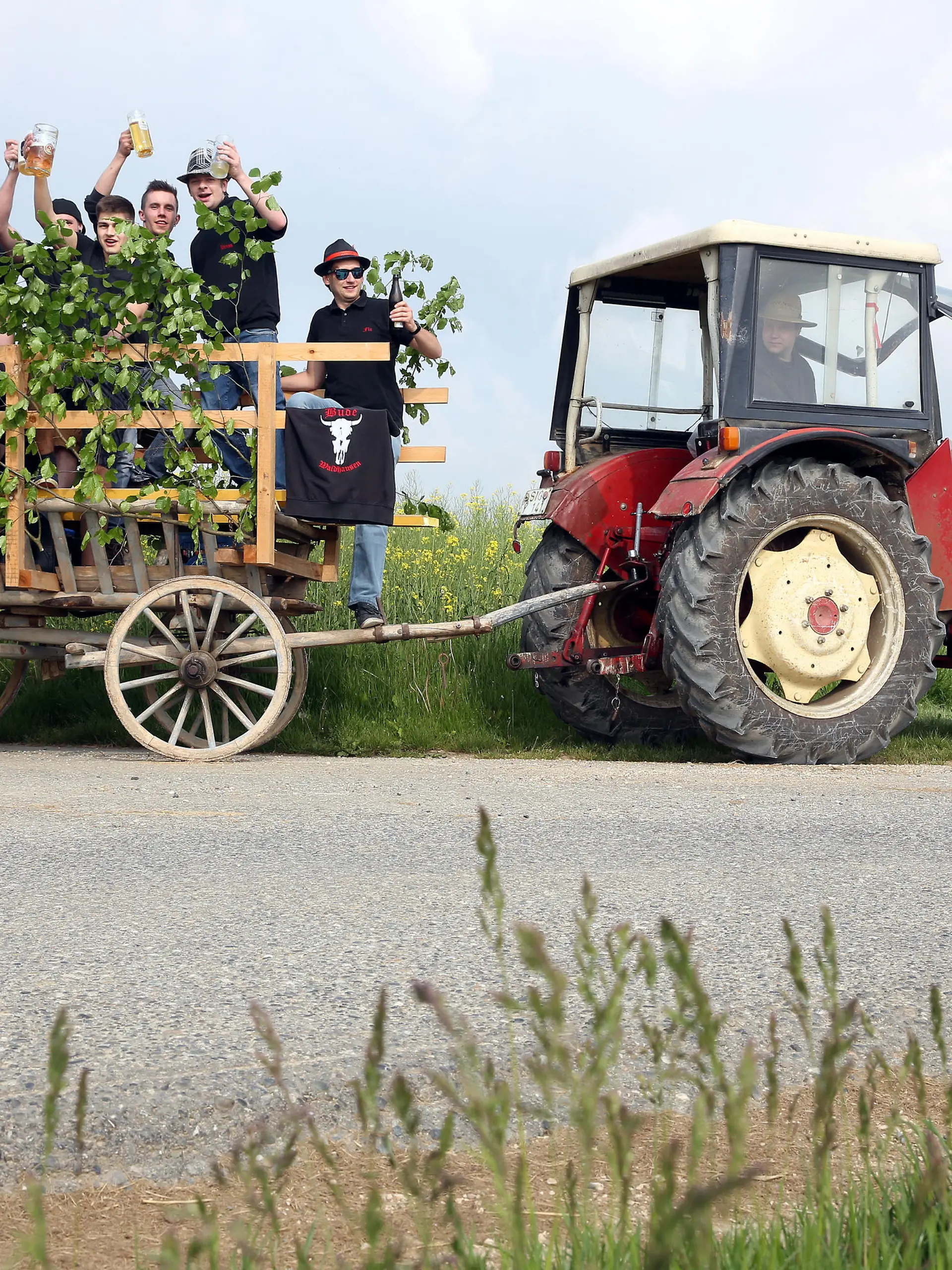 Eine Gruppe Männer ist am 25.05.2017 bei ihrer Vatertagstour mit einem Traktor und einem geschmückten Anhänger bei Waldhausen (Baden-Württemberg) unterwegs. Foto: Thomas Warnack/dpa | Verwendung weltweit