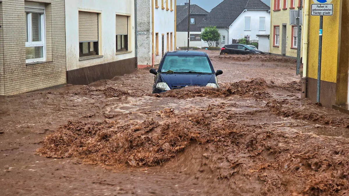 19.05.2024, Rheinland-Pfalz, Kirn: Ein Auto bahnt sich den Weg durch die Wassermassen. Extremer Starkregen hat am Sonntagnachmittag in der rheinland-pfälzischen Stadt Kirn zu Überflutungen und Erdrutschen geführt. Foto: Sebastian Schmitt/dpa +++ dpa-Bildfunk +++