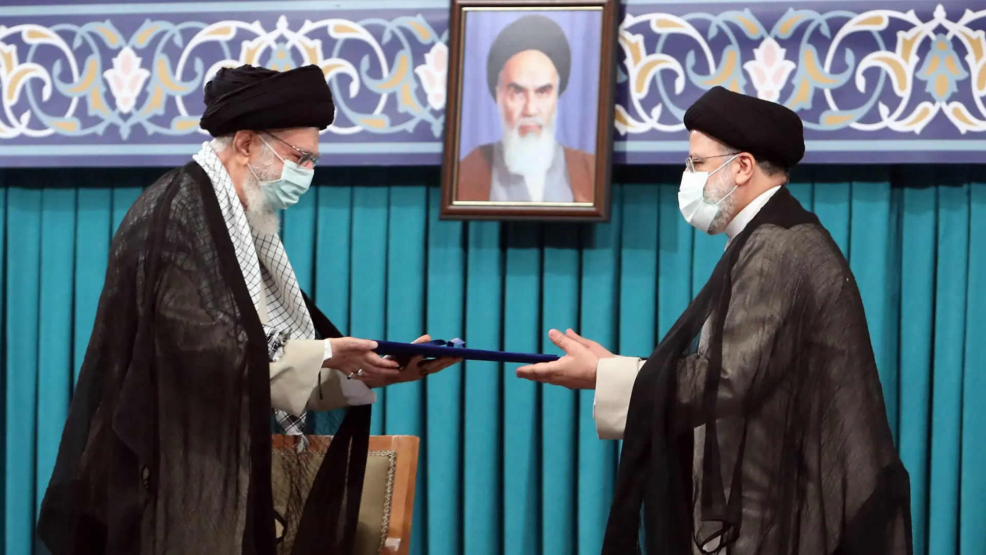 HANDOUT - 03.08.2021, Iran, Teheran: Ajatollah Ali Chamenei (l), Oberster Führer des Iran, überreicht Ebrahim Raisi, Präsident des Iran, während dessen Amtseinführung im Büro des Obersten Führers sein offizielles Siegel. Bei dem Absturz des Präsidenten-Hubschraubers im Iran sind Staatsmedien zufolge alle Insassen ums Leben gekommen. Unter den neun Toten sind Präsident Ebrahim Raisi und Außenminister Hussein Amirabdollahian, wie die staatliche Nachrichtenagentur Irna und das Staatsfernsehen am Montag berichteten. Foto: -/Iranian Supreme Leader's Office/dpa - ACHTUNG: Nur zur redaktionellen Verwendung und nur mit vollständiger Nennung des vorstehenden Credits +++ dpa-Bildfunk +++