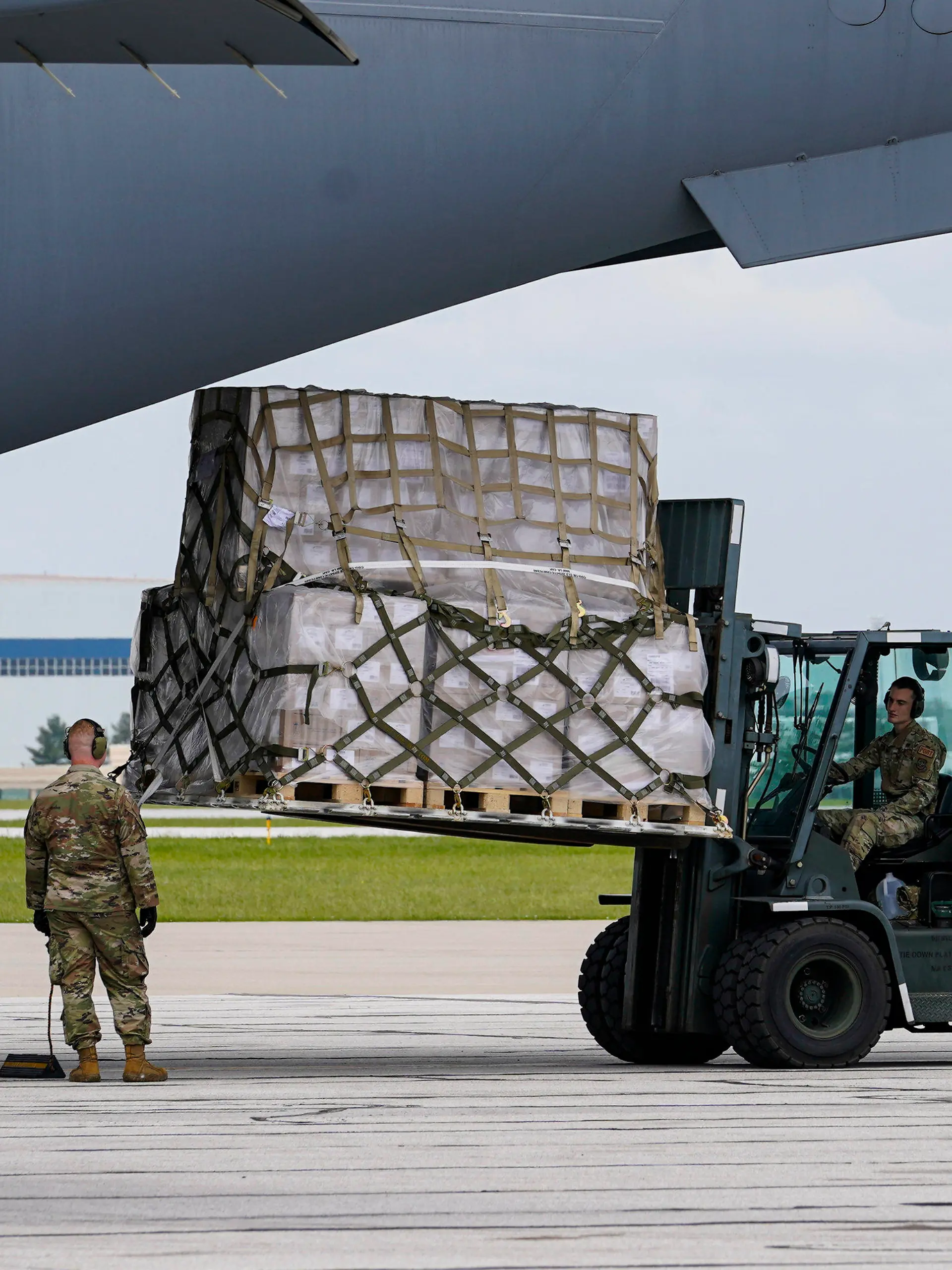 Crew members of an Air Force C-17 unload a plane load of baby formula at the Indianapolis International Airport in Indianapolis, Sunday, May 22, 2022. The 132 pallets of Nestlé Health Science Alfamino Infant and Alfamino Junior formula arrived from Ramstein Air Base in Germany. (AP Photo/Michael Conroy)