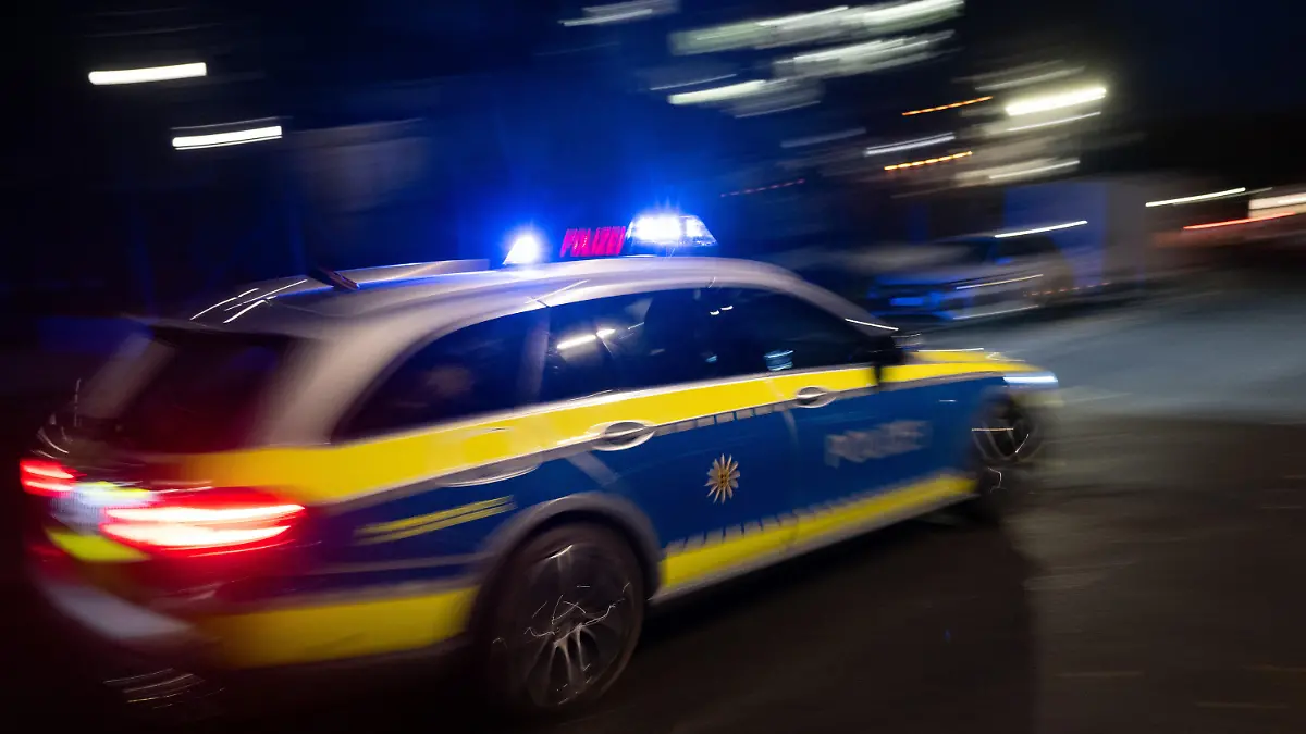 ILLUSTRATION - 30.11.2023, Baden-Württemberg, Stuttgart: Ein Polizeifahrzeug fährt im Rahmen mit Blaulicht an einem Gebäude vorbei (gestellte Szene, Langzeitblichtung mit Wischeffekt). (zu dpa: «Auto erfasst Kind an Bushaltestelle - Achtjähriger schwer verletzt») Foto: Marijan Murat/dpa +++ dpa-Bildfunk +++