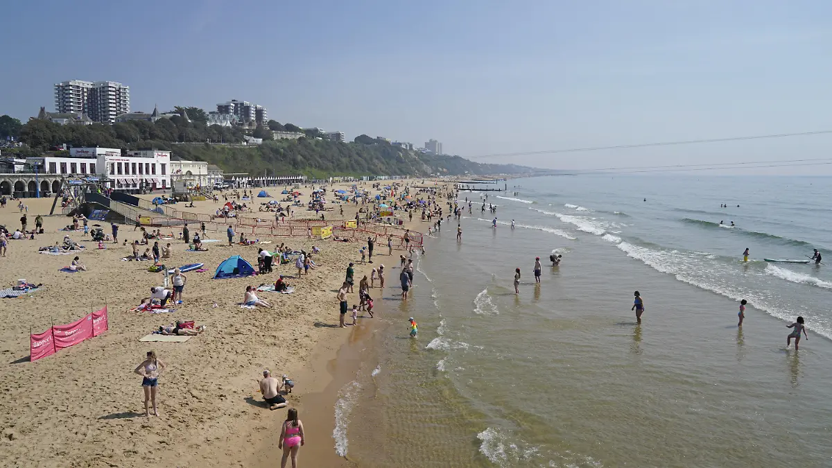 12.05.2024, Großbritannien, Bournemouth: Menschen halten sich bei sonnigem Wetter am Strand von Bournemouth auf. Foto: Andrew Matthews/PA Wire/dpa +++ dpa-Bildfunk +++
