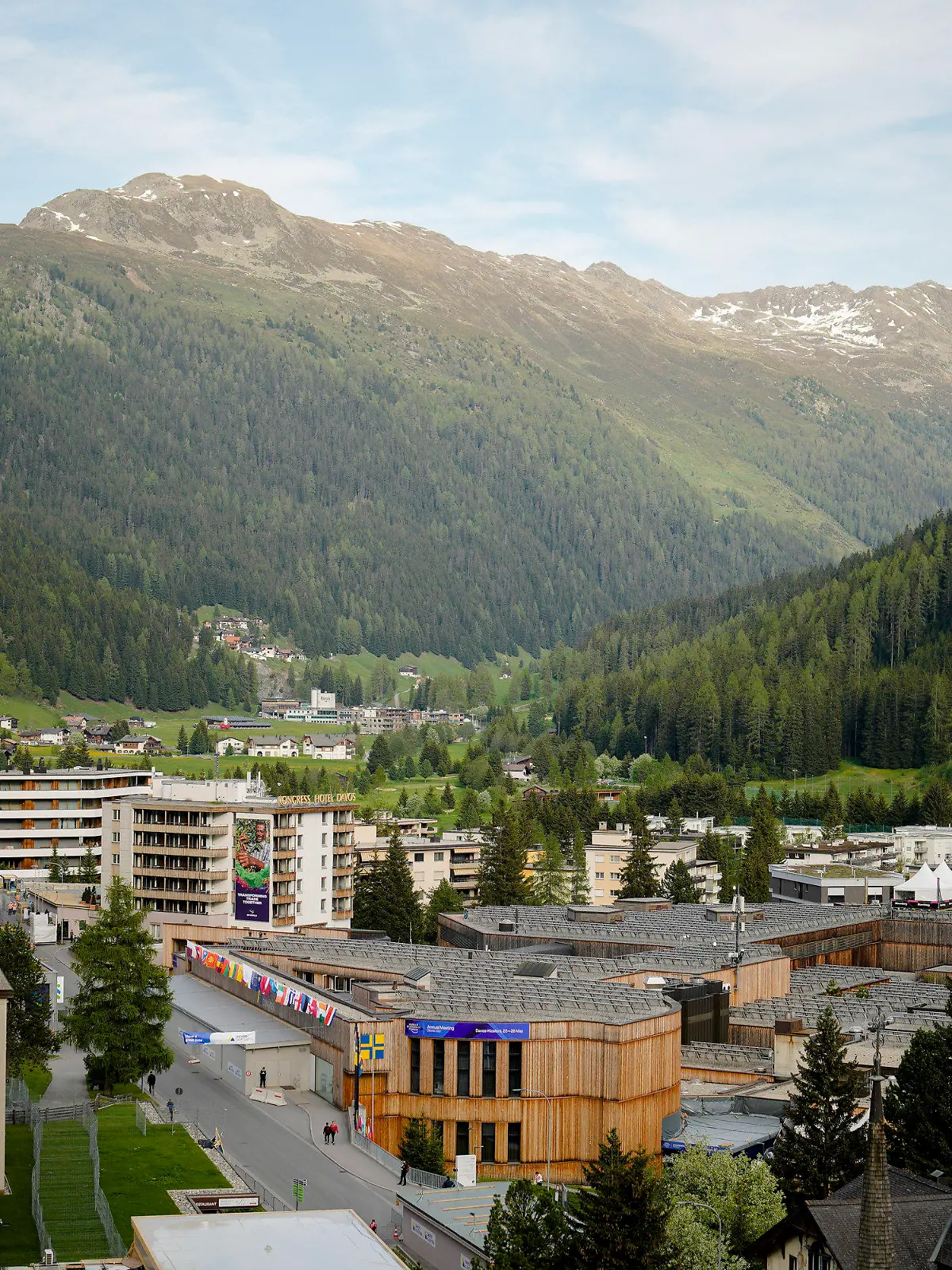 People walk in front of the Davos Congress Center, where the World Economic Forum will take place, on the eve of the event in Davos, Switzerland, Saturday, Jan. 21, 2022. The annual meeting of the World Economic Forum is taking place in Davos from May. 22 until May. 26, 2020. (AP Photo/Markus Schreiber)