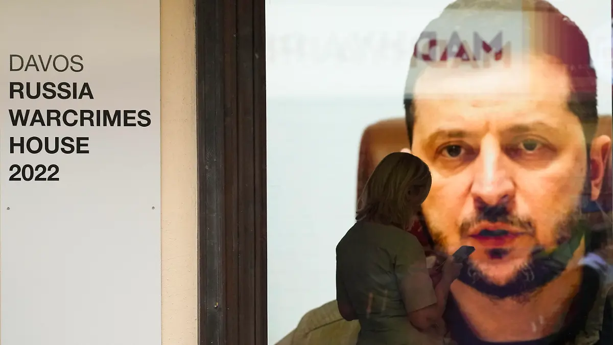 22.05.2022, Schweiz, Davos: Der ukrainische Präsident Selenskyj spricht auf einem Bildschirm im sogenannten Russischen Kriegsverbrecherhaus am Rande des Weltwirtschaftsforums. In dem Haus soll eine Ausstellung mit Bildern gezeigt werden, die mutmaßliche russische Kriegsverbrechen im Ukraine-Krieg dokumentieren. Das jährliche Treffen des Weltwirtschaftsforums findet in Davos vom 22. bis 26. Mai 2022 statt. Foto: Markus Schreiber/AP/dpa +++ dpa-Bildfunk +++