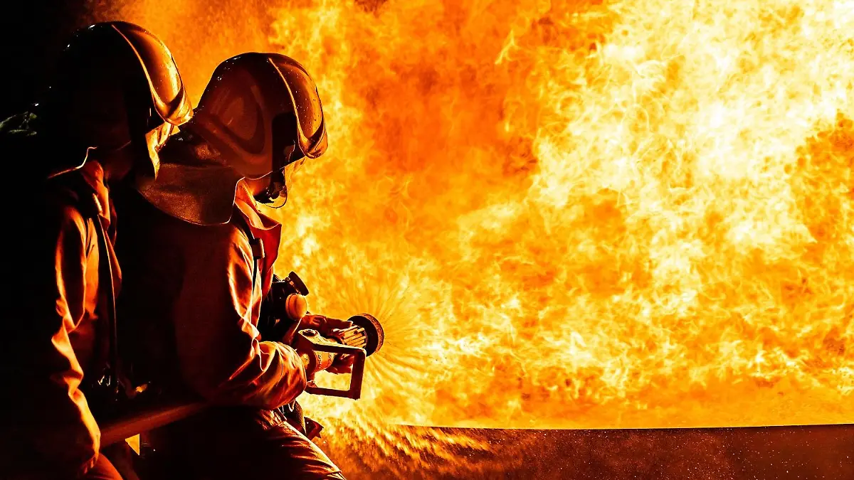 Firefighters using Twirl water fog type fire extinguisher to fighting with the fire flame from oil to control fire not to spreading out. Firefighter and industrial safety concept.