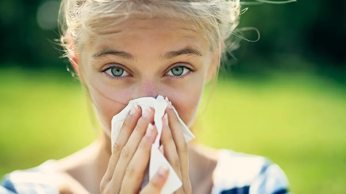 Portrait of teenage girl blowing her nose on a summer day. The girl is allergic to the pollen.
Nikon D850