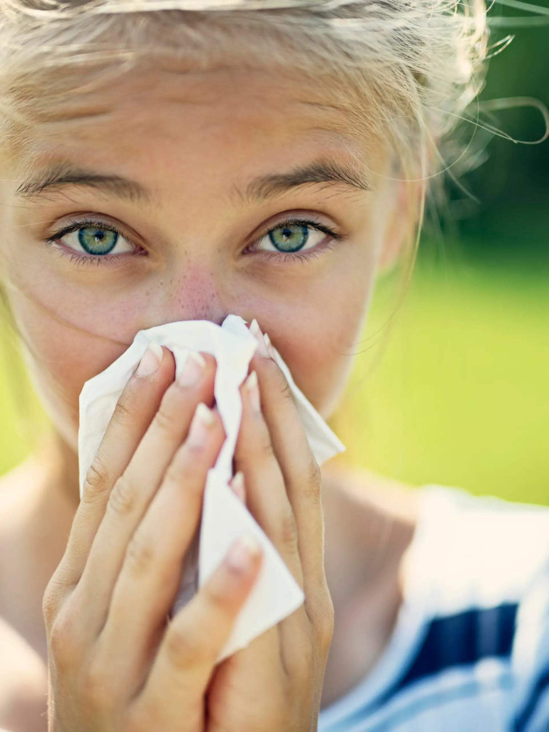 Portrait of teenage girl blowing her nose on a summer day. The girl is allergic to the pollen.
Nikon D850