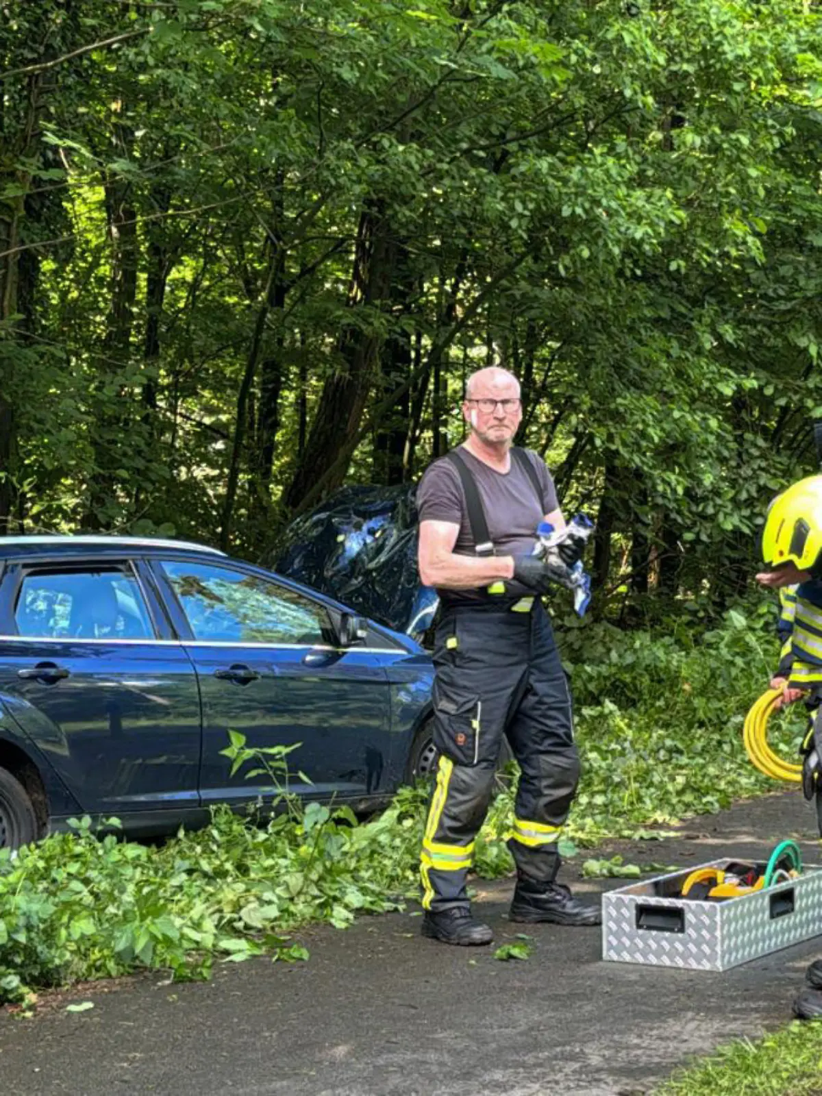 25.05.2024, Nordrhein-Westfalen, Schloß Holte-Stukenbrock: Feuerwehr und Rettungsteams stehen an der Unglückstelle, nachdem ein Auto in eine Gruppe von Joggern gefahren ist. In Schloß Holte-Stukenbrock bei Bielefeld ist am Samstag ein 19-jähriger Autofahrer in eine Gruppe von Joggern gerast. Dabei seien drei Menschen schwer verletzt worden, sagte eine Polizeisprecherin. Foto: Christian Müller/Westfalennews/dpa +++ dpa-Bildfunk +++
