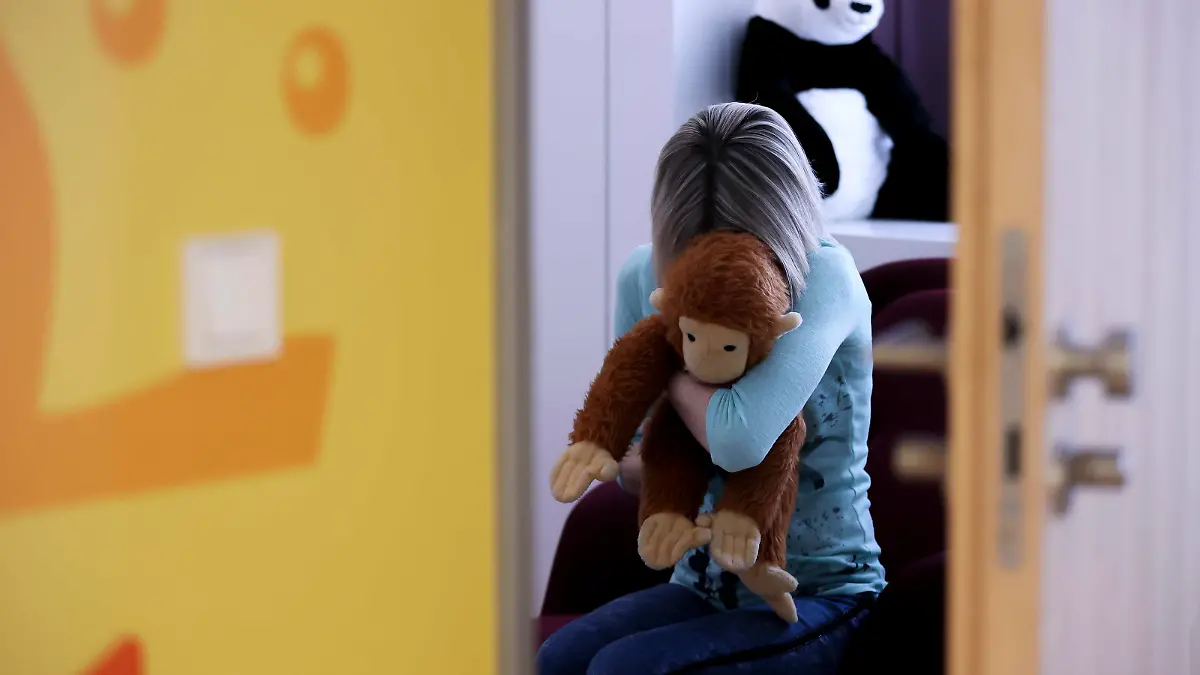 ARCHIV - 14.03.2022, Sachsen, Leipzig: ILLUSTRATION - Eine junge Frau sitzt mit einem Kuscheltier im Arm in einem Raum des Childhood House, in dem Kinder und Jugendliche, die von Missbrauchs betroffen sind, vernommen werden können (gestellte Szene). (zu dpa: «Gesetz zu Umgang mit sexuellem Missbrauch soll im Juni ins Kabinett») Foto: Jan Woitas/dpa +++ dpa-Bildfunk +++