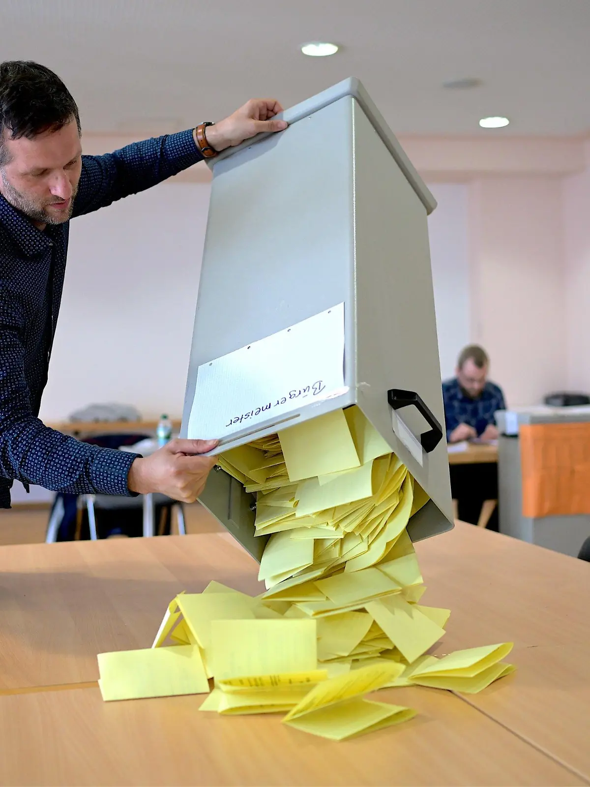 26.05.2024, Thüringen, Arnstadt: Der Wahlvorsteher im Wahllokal für den Wahlkreis 114, Miklos Szatmari, schüttet die Wahlurne für die Auszählung der Stimmzettel für Bürgermeisterwahl in Arnstadt aus. In Thüringen werden eine Vielzahl von Stadt- und Gemeinderäten, 94 Oberbürgermeister und Bürgermeister sowie 13 Landräte gewählt. Die Stichwahlen sind für den Tag der Europawahl (9. Juni) geplant. Foto: Jacob Schröter/dpa +++ dpa-Bildfunk +++