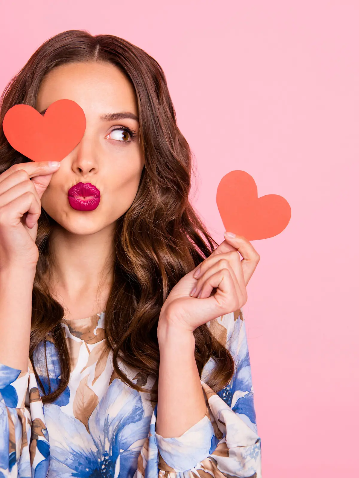 Close-up portrait of her she, nice-looking attractive lovely coquettish cheerful cheery wavy-haired girl holding in hands two small little heart sending you kiss isolated over pink pastel background