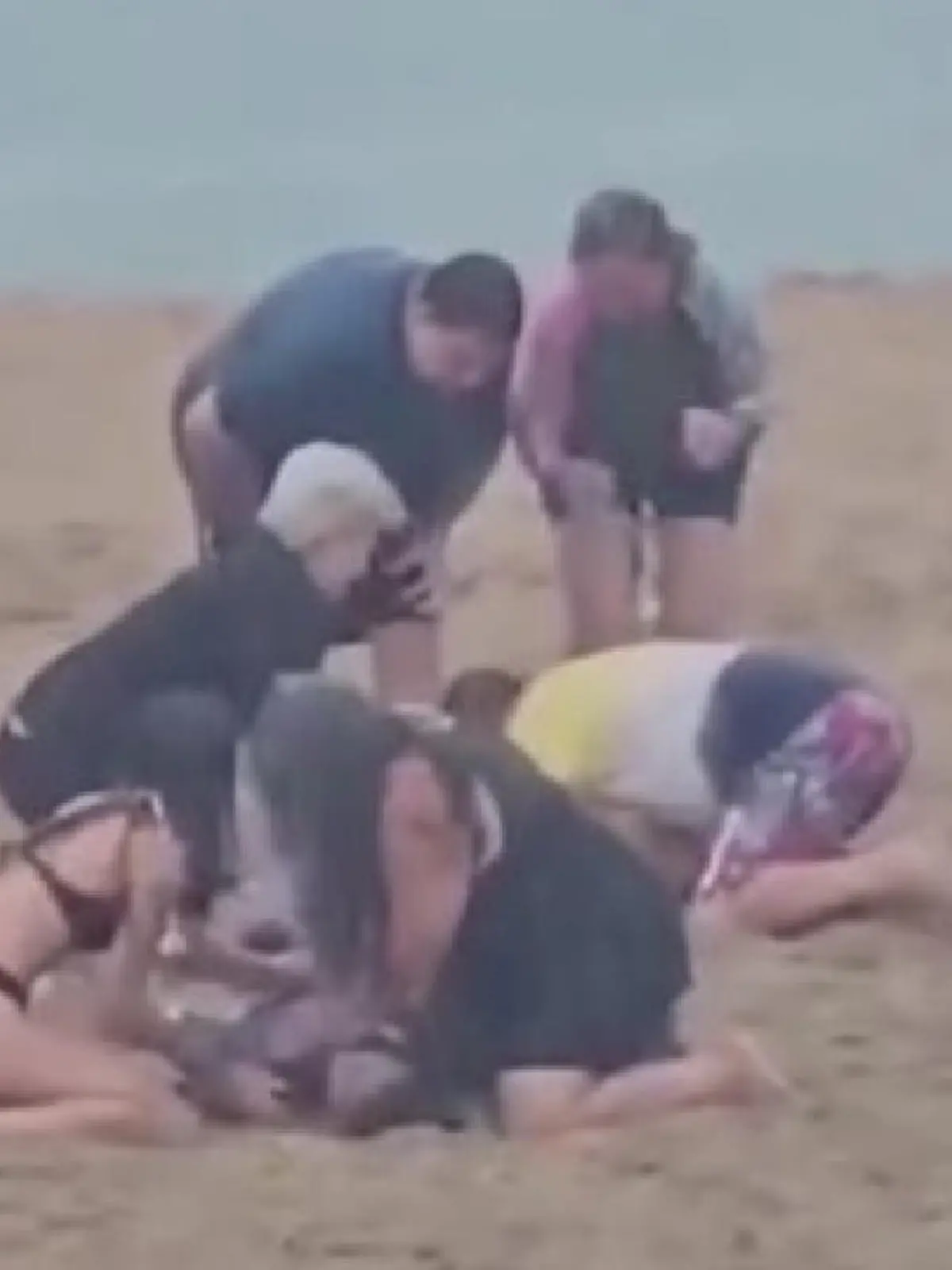 Verzweifelt versuchen die Menschen am Strand den drei Kindern erste Hilfe zu leisten.