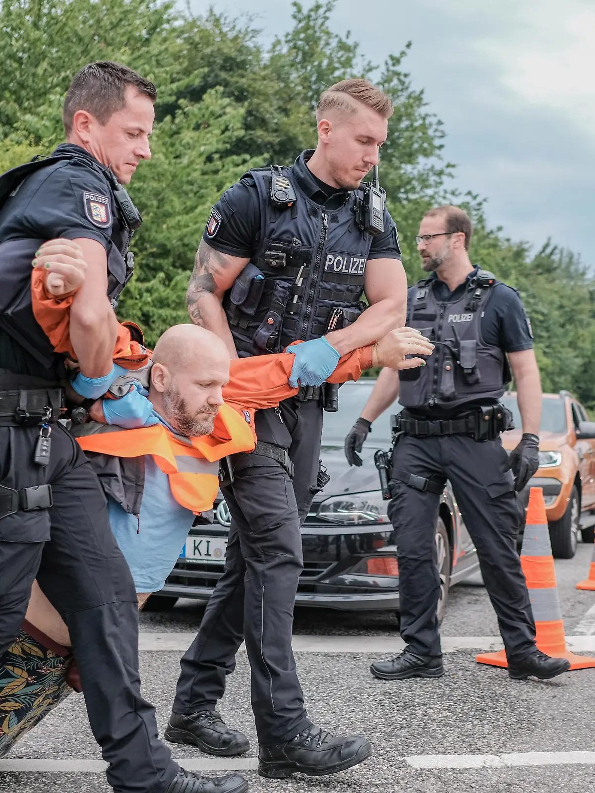 Sechs Aktivist*innen der Letzten Generation blockierten am 10.7.2023 die Ausfahrt der Bundesstrasse 76 in Kiel. Die Letzte Generation fordert ein Tempolimit von 100 km/h auf Autobahnen, die Einfuehrung eines Neun-Euro-Tickets und einen Gesellschaftsrat Klima.   --   6 activists of the Last Generation blocked the exit ramp of the B76 in Kiel, Germany. The Last Generation demands a speed limit of 100 km/h on highways, the introduction of a nine-euro ticket and a Climate Society Council.