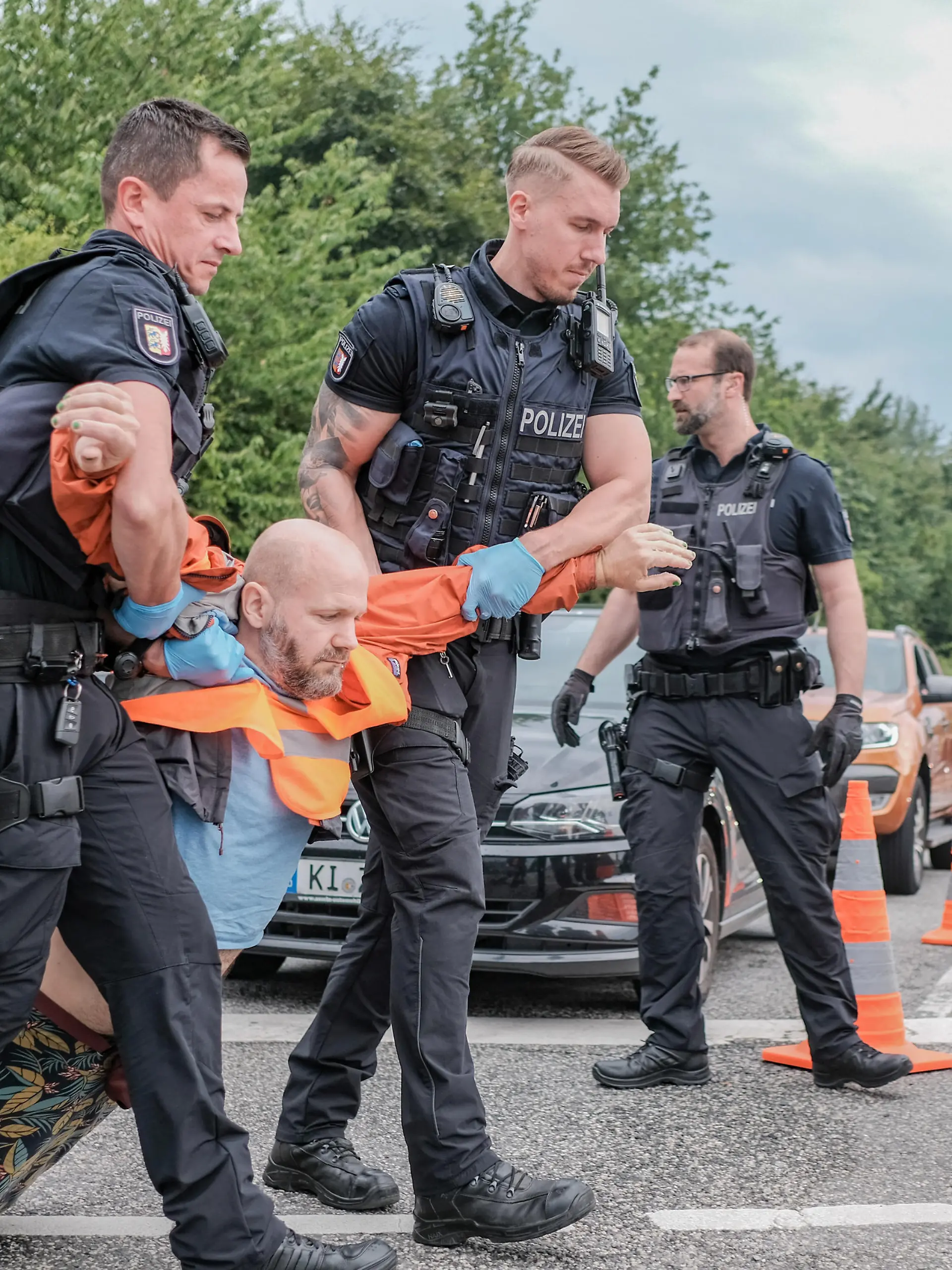 Sechs Aktivist*innen der Letzten Generation blockierten am 10.7.2023 die Ausfahrt der Bundesstrasse 76 in Kiel. Die Letzte Generation fordert ein Tempolimit von 100 km/h auf Autobahnen, die Einfuehrung eines Neun-Euro-Tickets und einen Gesellschaftsrat Klima.   --   6 activists of the Last Generation blocked the exit ramp of the B76 in Kiel, Germany. The Last Generation demands a speed limit of 100 km/h on highways, the introduction of a nine-euro ticket and a Climate Society Council.