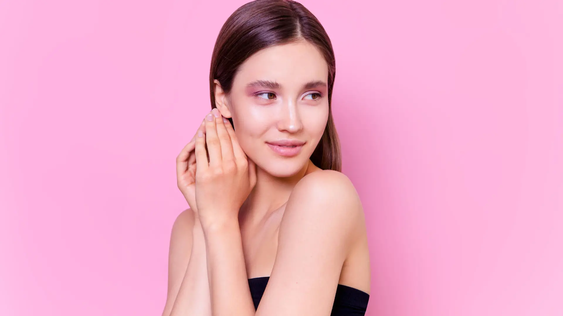 Beautiful brunette young woman on pink background Fashion model close-up beauty shot Flawless skin perfect nude colored glowing make up