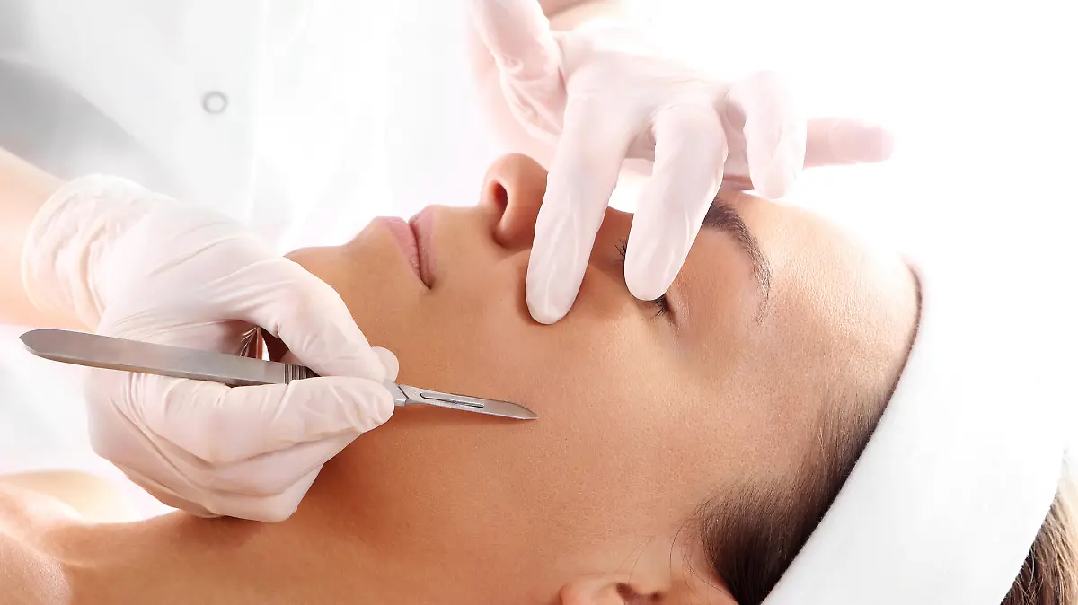 Caucasian woman during surgery using a scalpel