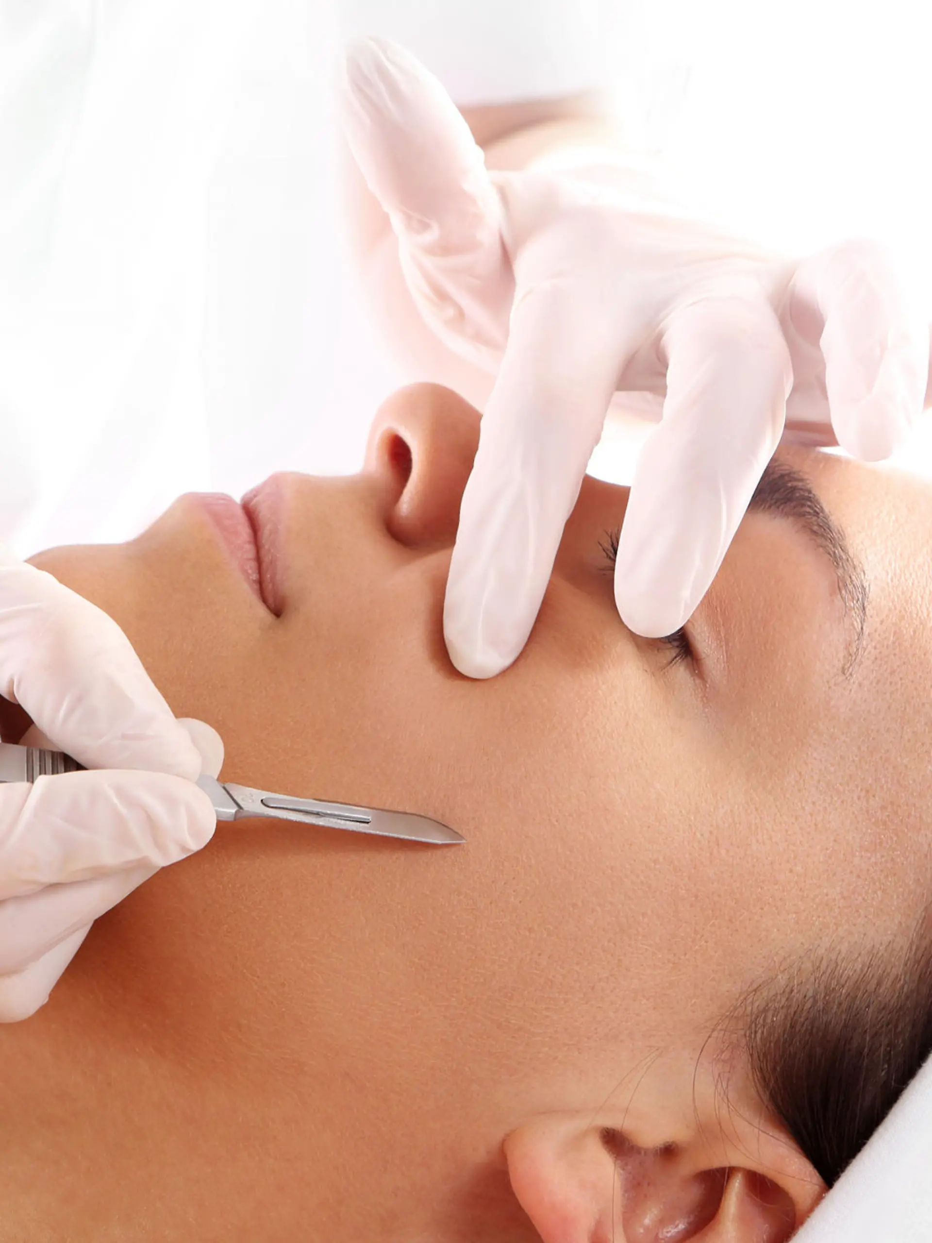 Caucasian woman during surgery using a scalpel