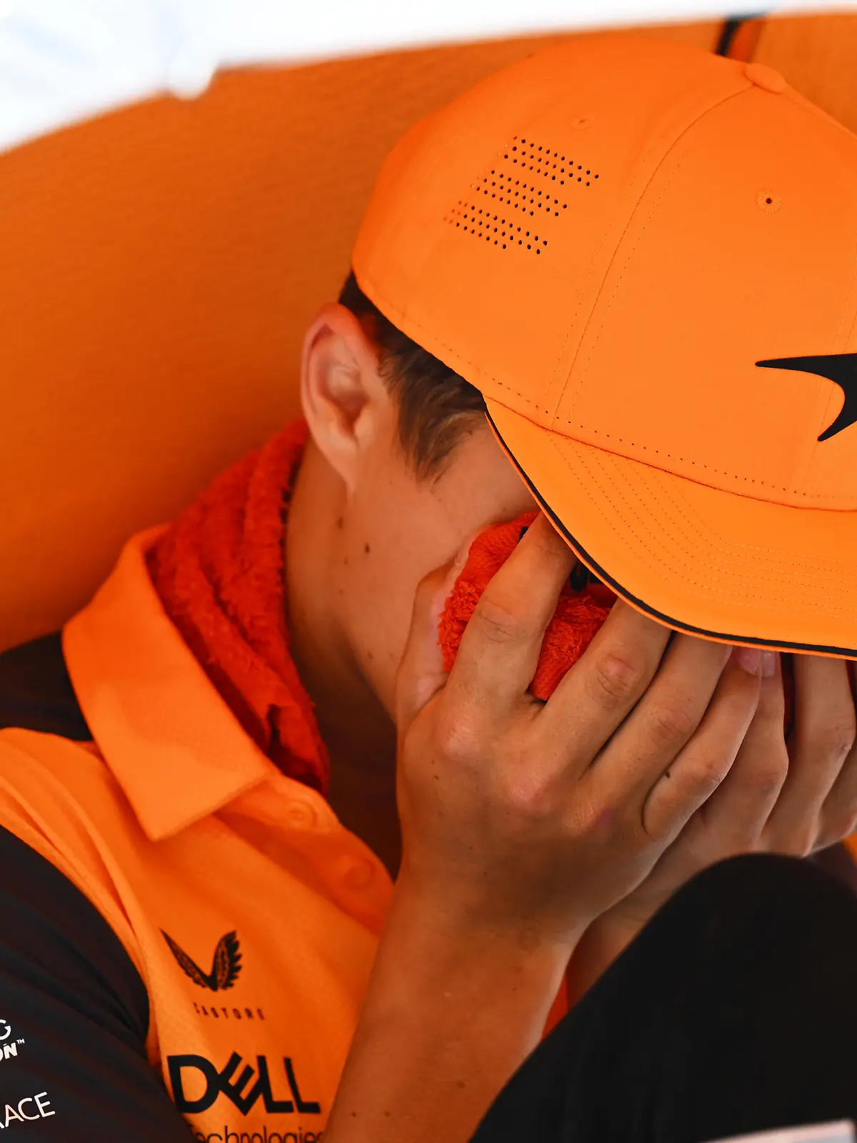 BARCELONA, SPAIN - MAY 22: Lando Norris of Great Britain and McLaren reacts to the heat on the drivers parade with a cool pack on his face prior to the F1 Grand Prix of Spain at Circuit de Barcelona-Catalunya on May 22, 2022 in Barcelona, Spain. (Photo by Clive Mason/Getty Images)