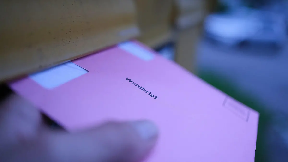 31.05.2024, Baden-Württemberg, Stuttgart: Eine Hand hält an einem Briefkasten einen Wahlbrief für die Stimmzettel der Wahlen für das Europaparlament, die Regionalversammlung und den Gemeinderat. Foto: Bernd Weißbrod/dpa +++ dpa-Bildfunk +++