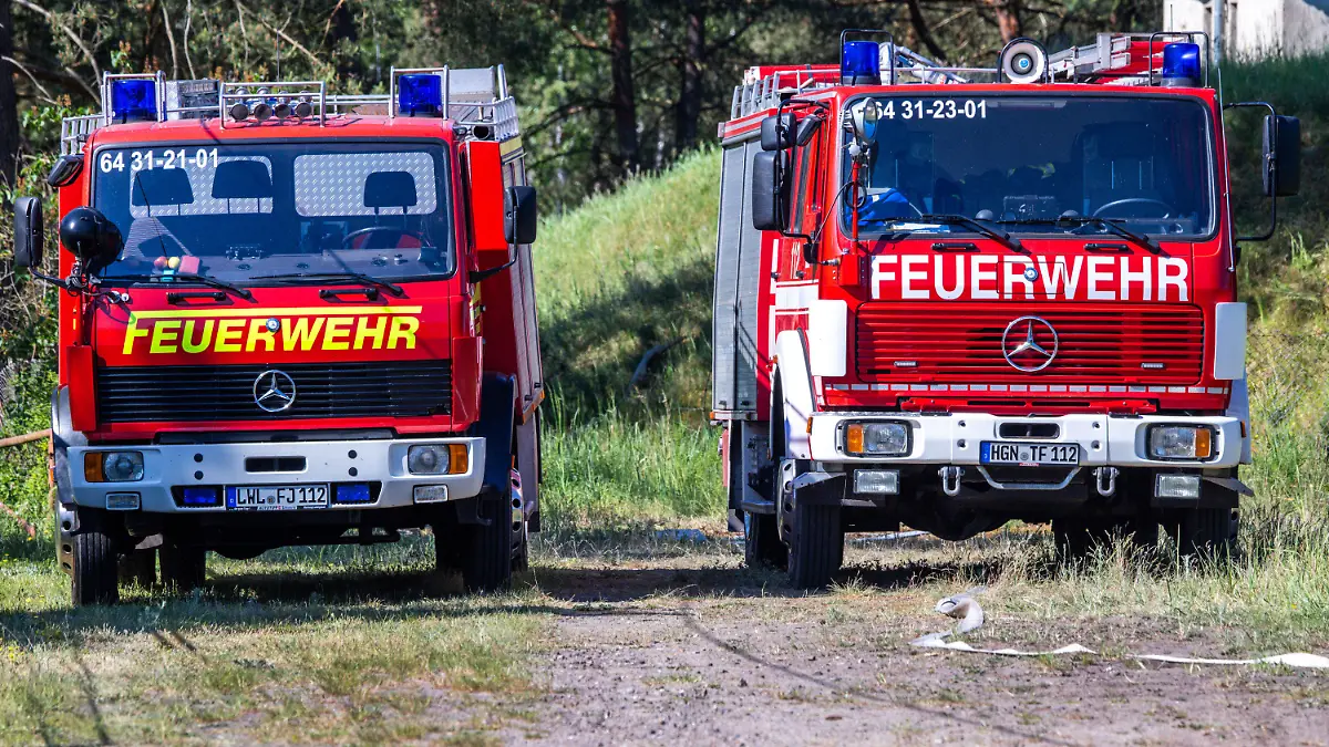 16.05.2024, Mecklenburg-Vorpommern, Lübtheen: Feuerwehrfahrzeuge stehen in der Nähe der mittlerweile gelöschten Brandstelle auf dem ehemaligen Truppenübungsplatz. Am Abend des 15.05.2024 war ein Feuer ausgebrochen, Einsatzkräfte der Feuerwehr konnten den etwa drei Hektar großen Brandherd bekämpfen. Im Sommer 2019 hatte sich über die Jahre freigelegte Munition vermutlich selbst entzündet und ein Feuer verursacht, das fast 1.000 Hektar Wald erfasste. Foto: Jens Büttner/dpa +++ dpa-Bildfunk +++