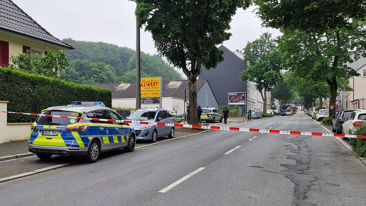 01.06.2024, Nordrhein-Westfalen, Hagen: Einsatzfahrzeuge der Polizei stehen in einer abgesperten Straße.Durch Schüsse an zwei Orten sind am Samstag in Hagen insgesamt vier Menschen verletzt worden. Eine Person habe lebensgefährliche Verletzungen erlitten, sagte ein Sprecher der federführenden Polizei Dortmund. Nähere Angaben machte die Polizei zunächst nicht. Ein Täter befand sich am frühen Samstagnachmittag laut Polizei auf der Flucht. Nach ihm werde mit Hochdruck gefahndet. Die Polizei Dortmund schloss aber auch nicht aus, dass es mehrere Täter geben könne. Foto: Justin Brosch/dpa +++ dpa-Bildfunk +++