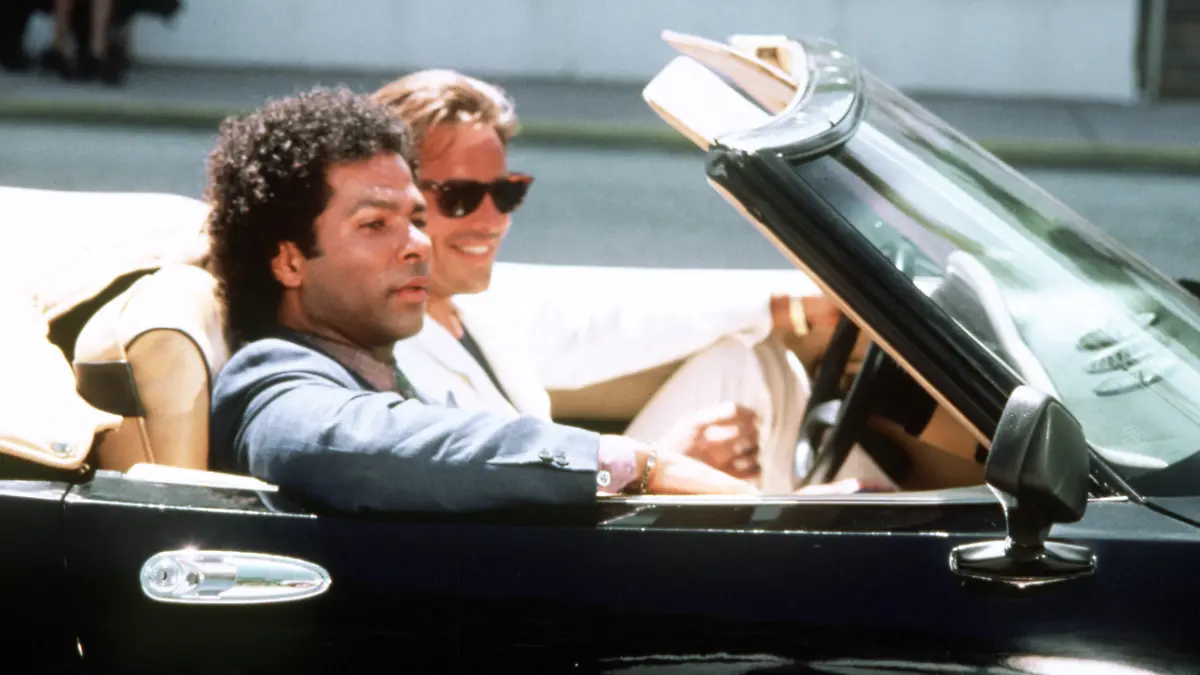 Die beiden Hauptdarsteller der erfolgreichen US-Krimi-Serie "Miami Vice" Philip Michael Thomas (vorn) als Detective Ricardo Tubbs und Don Johnson als Detective James "Sonny" Crocket in einem Sportwagen-Cabrio. (Aufnahme von 1986). +++(c) dpa - Report+++